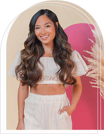 A woman wearing a crop top and pants, showcasing her stylish hair extensions.