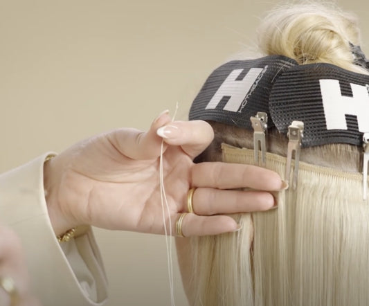 A hairdresser is showcasing the hair extension sewing method for weft hair extensions.