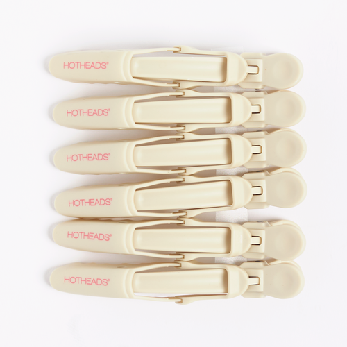 A set of cream-colored hair clips with pink text reading Hotheads.