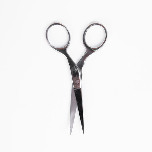 A close-up view of a pair of scissors positioned on a plain white background.