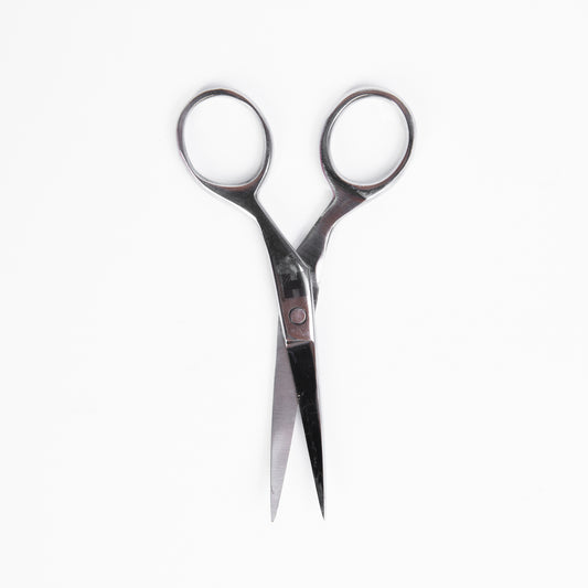 A close-up view of a pair of scissors positioned on a plain white background.