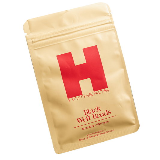 A packet of black weft beads by Hotheads, designed for hair extensions, featuring a peach color accent.
