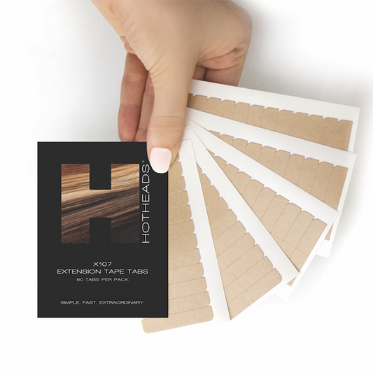 A person holding a tape pack of X107 Extension tape tabs, featuring a brown and white design, with 60 tabs included.
